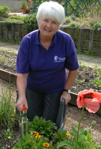 Kneeling to plant with a bulb planter